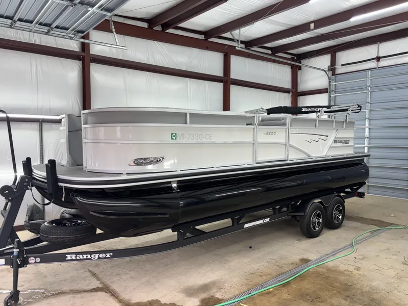 Slide: The Image of 2024 Ranger 220C pontoon boat on trailer in a garage setting. - 8