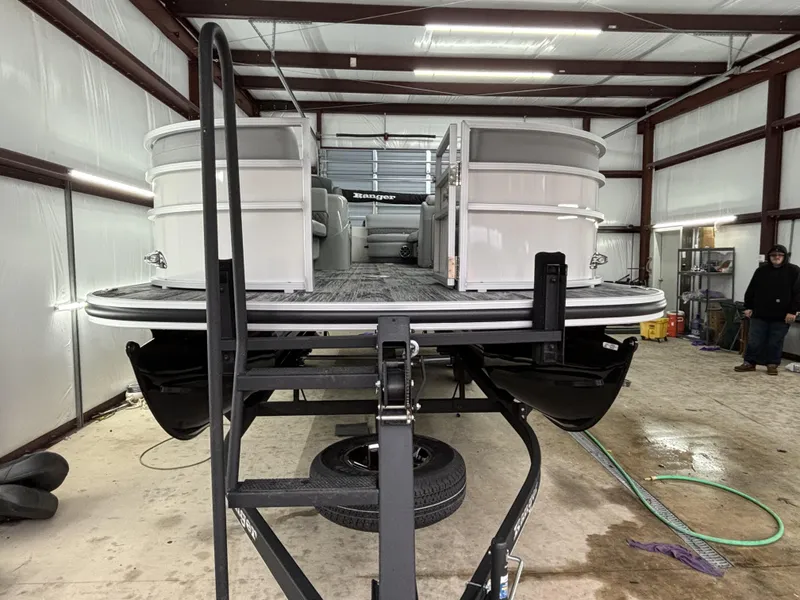 Slide: The Image of 2024 Ranger 220C pontoon boat in a garage, viewed from the front. - 9