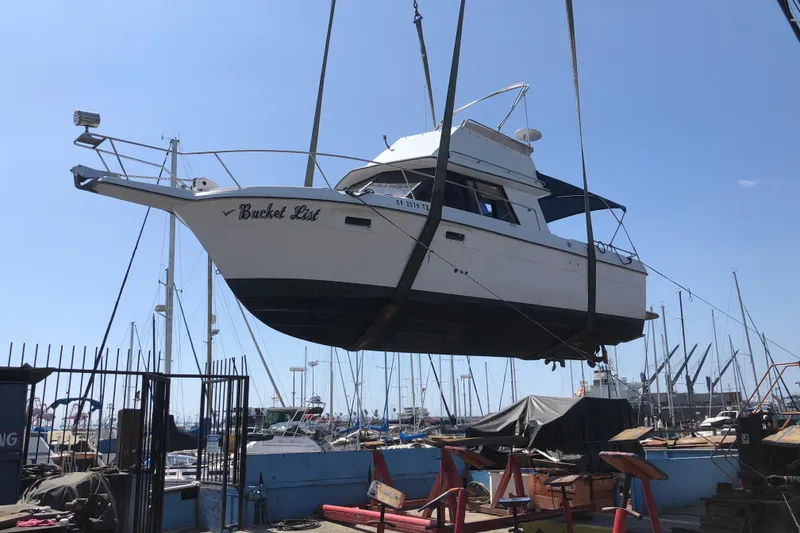 Slide: The Image of 1988 Cruisers Esprit 2980 boat being lifted at a marina. - 3