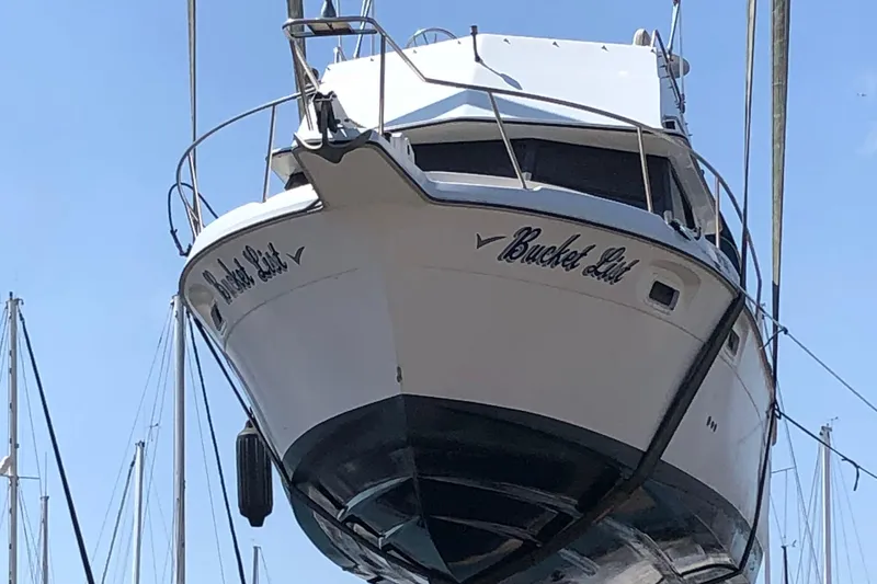 Slide: The Image of 1988 Cruisers Esprit 2980 boat named "Bucket List" in a marina setting. - 6