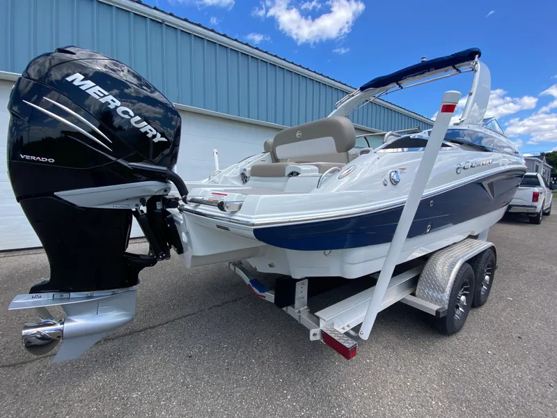 Slide: The Image of 2023 Crownline 280 XSS boat with Mercury engine on a trailer, parked outdoors. - 11