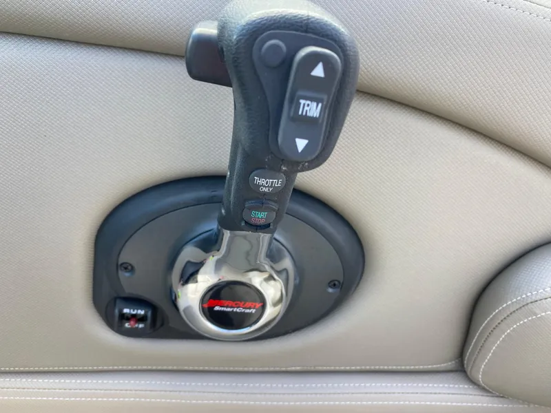 Slide: The Image of Throttle control of 2023 Crownline 280 XSS boat, featuring trim and ignition switches. - 16