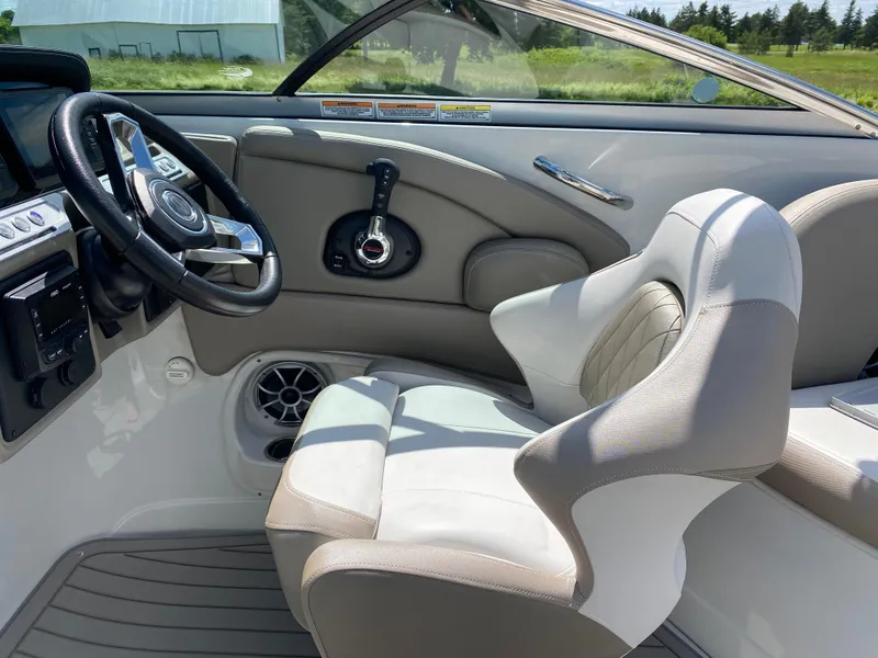 Slide: The Image of 2023 Crownline 280 XSS boat interior with steering wheel and comfortable seating. - 21