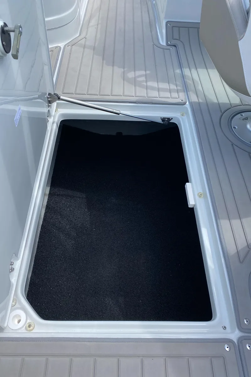 Slide: The Image of 2023 Crownline 280 XSS boat storage compartment with open hatch on deck. - 25