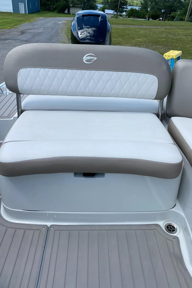 Slide: The Image of 2023 Crownline 280 XSS boat seat with beige and white upholstery, outdoor setting. - 28