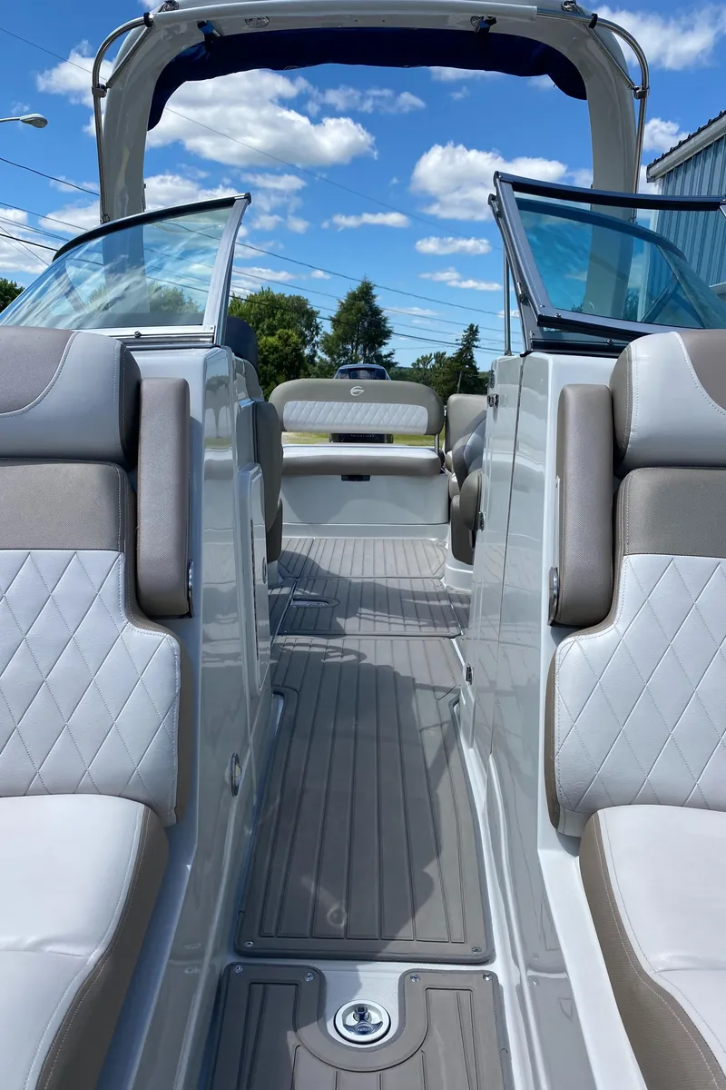 Slide: The Image of 2023 Crownline 280 XSS boat interior with luxurious seating and open deck under blue sky. - 36