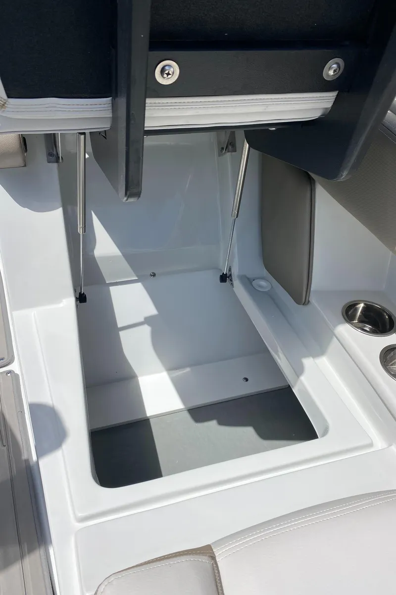 Slide: The Image of 2023 Crownline 280 XSS boat storage compartment with cup holders and seating area. - 38