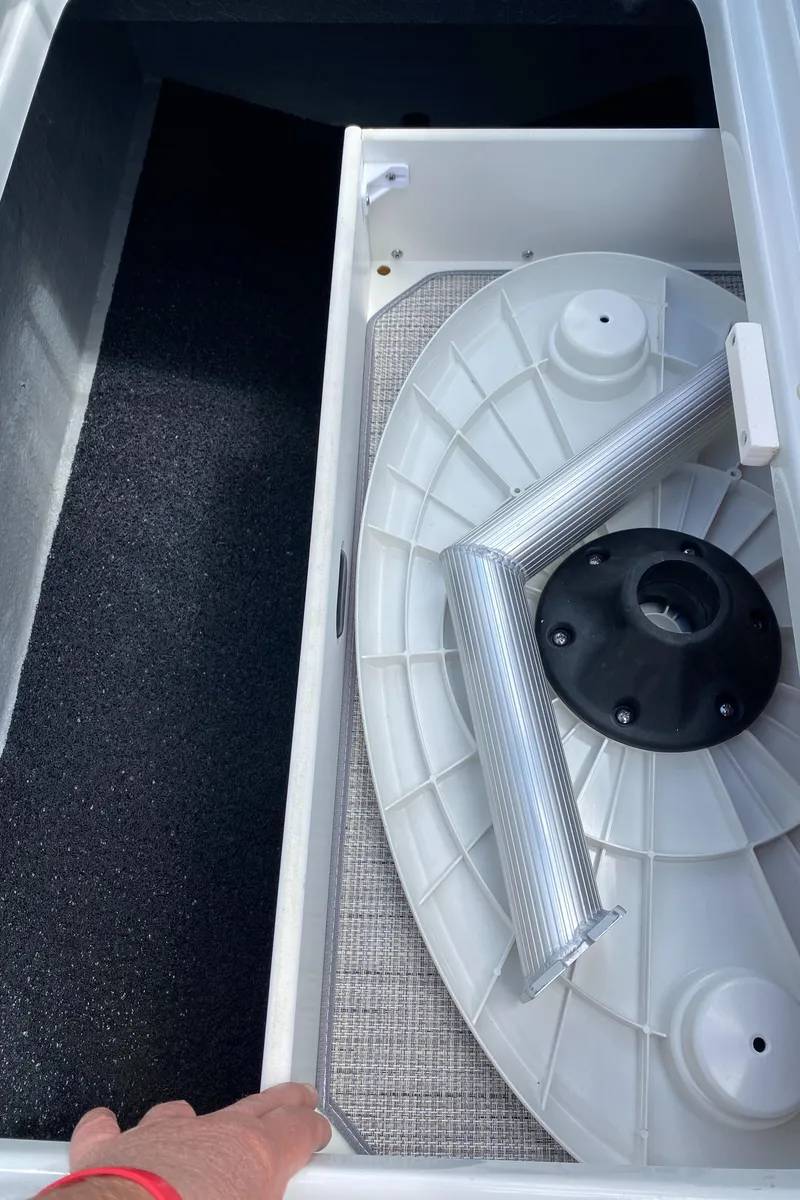 Slide: The Image of 2023 Crownline 280 XSS boat storage compartment with accessories and textured flooring. - 42
