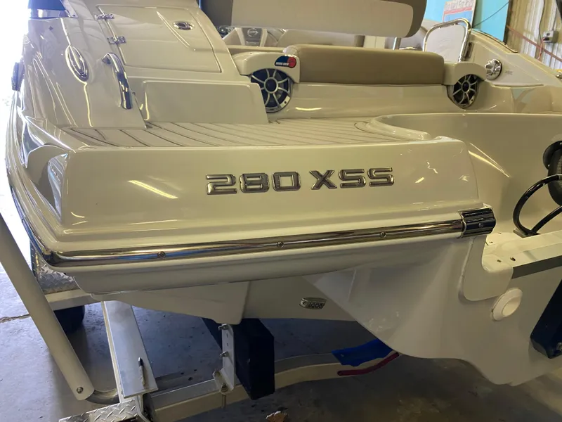 Slide: The Image of 2023 Crownline 280 XSS boat rear view in a garage setting. - 6