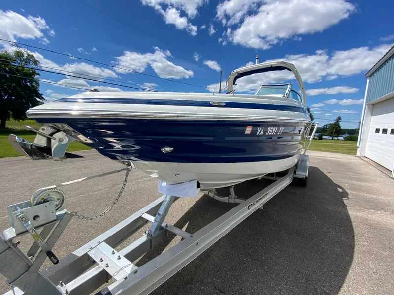Slide: The Image of 2023 Crownline 280 XSS boat on trailer under blue sky. - 7