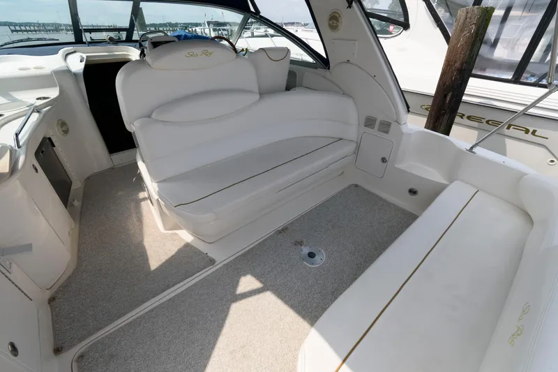 Slide: The Image of 1999 Sea Ray 340 Sundancer boat interior with white seating and carpeted floor. - 1