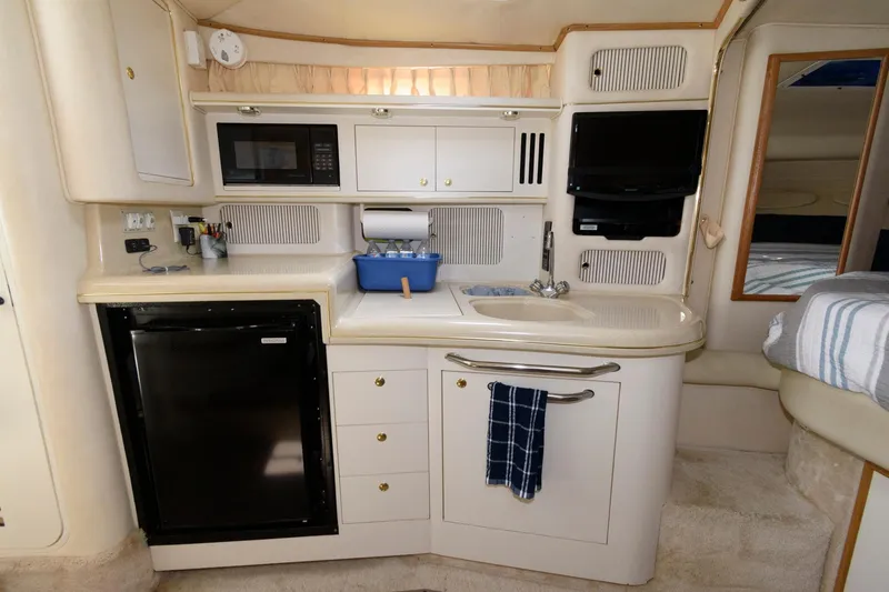 Slide: The Image of Compact kitchen area in a 1999 Sea Ray 340 Sundancer yacht with modern amenities. - 10