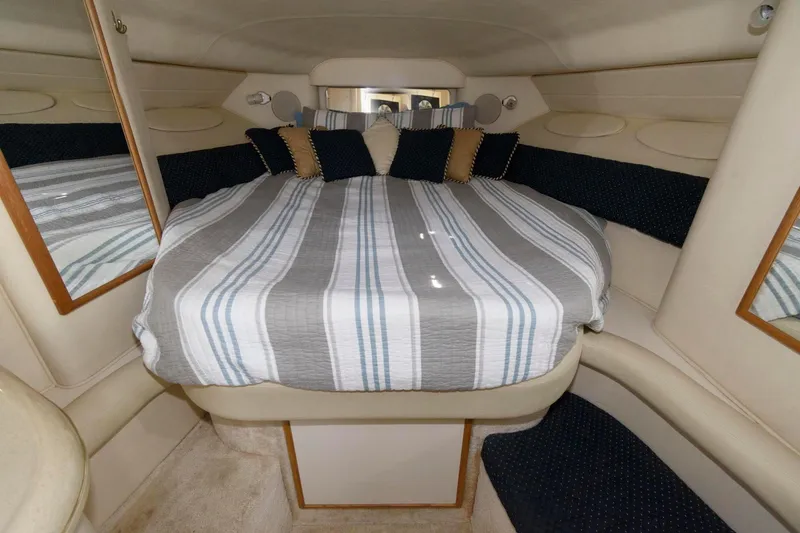 Slide: The Image of 1999 Sea Ray 340 Sundancer cabin with cozy bed and striped bedding. - 12