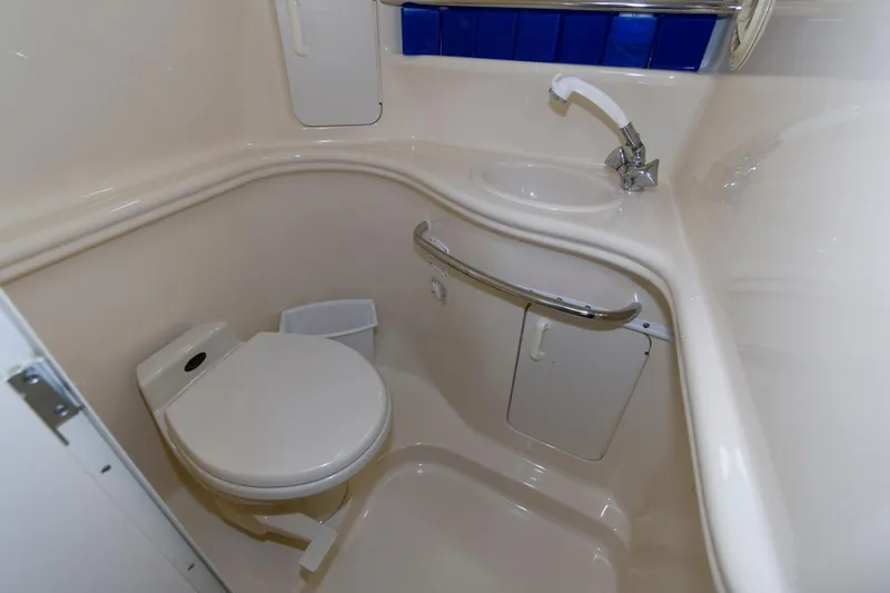 Slide: The Image of 1999 Sea Ray 340 Sundancer bathroom with toilet, sink, and storage compartments. - 14