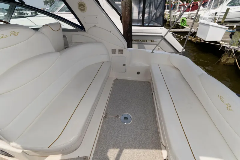 Slide: The Image of 1999 Sea Ray 340 Sundancer boat interior with white seating and carpeted floor. - 2