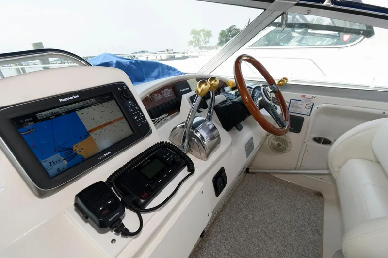 Slide: The Image of 1999 Sea Ray 340 Sundancer helm with navigation system and wooden steering wheel. - 4