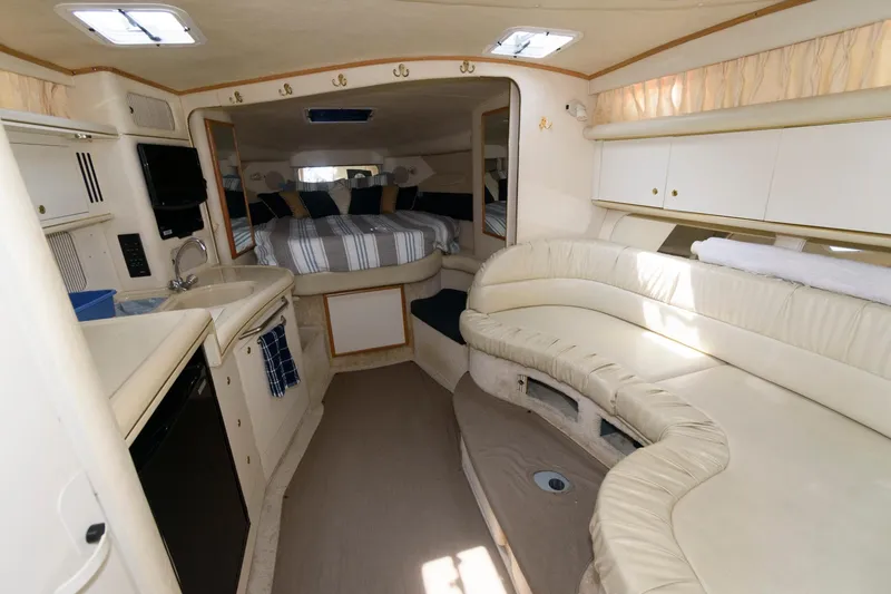 Slide: The Image of 1999 Sea Ray 340 Sundancer interior with kitchen, seating area, and bed. - 9