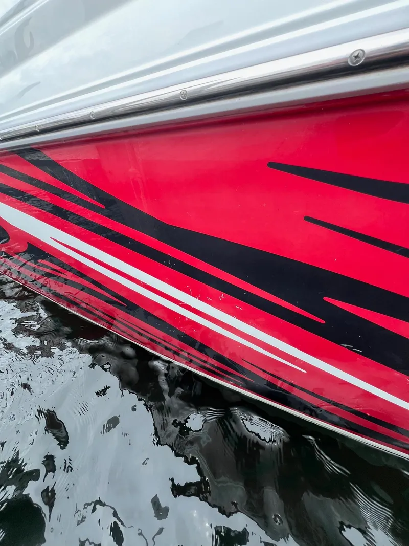 Slide: The Image of 2007 Baja Outlaw 260 boat with red and black graphics on the water. - 4