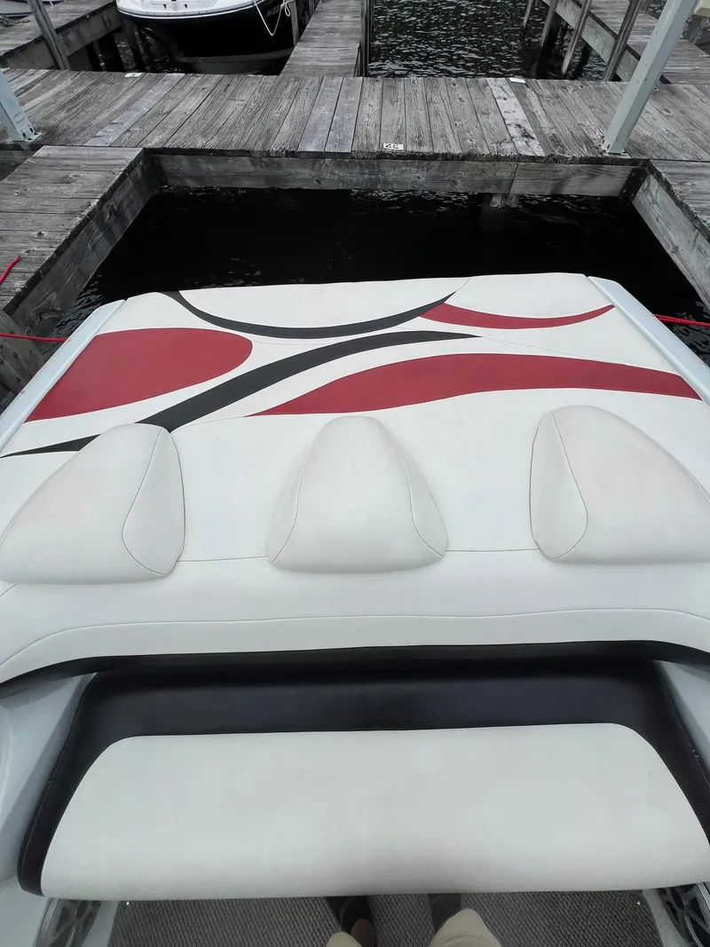 Slide: The Image of 2007 Baja Outlaw 260 boat with red and black accents docked at a marina. - 6