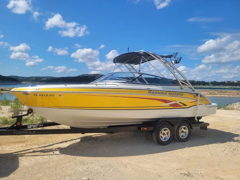 Slide: The Image of 2007 Formula 240 BR boat on trailer by a lake under a blue sky. - 14