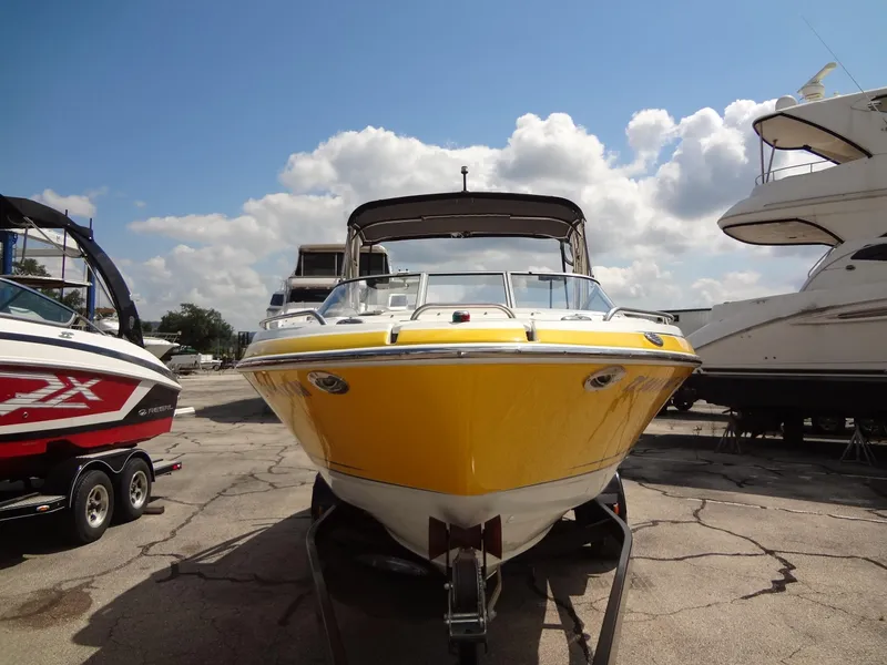 Slide: The Image of 2007 Formula 240 BR boat in yellow, docked at a marina. - 20