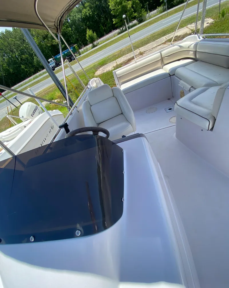 Slide: The Image of 1997 Chaparral 250 Sunseta boat interior with white seating and steering console. - 13