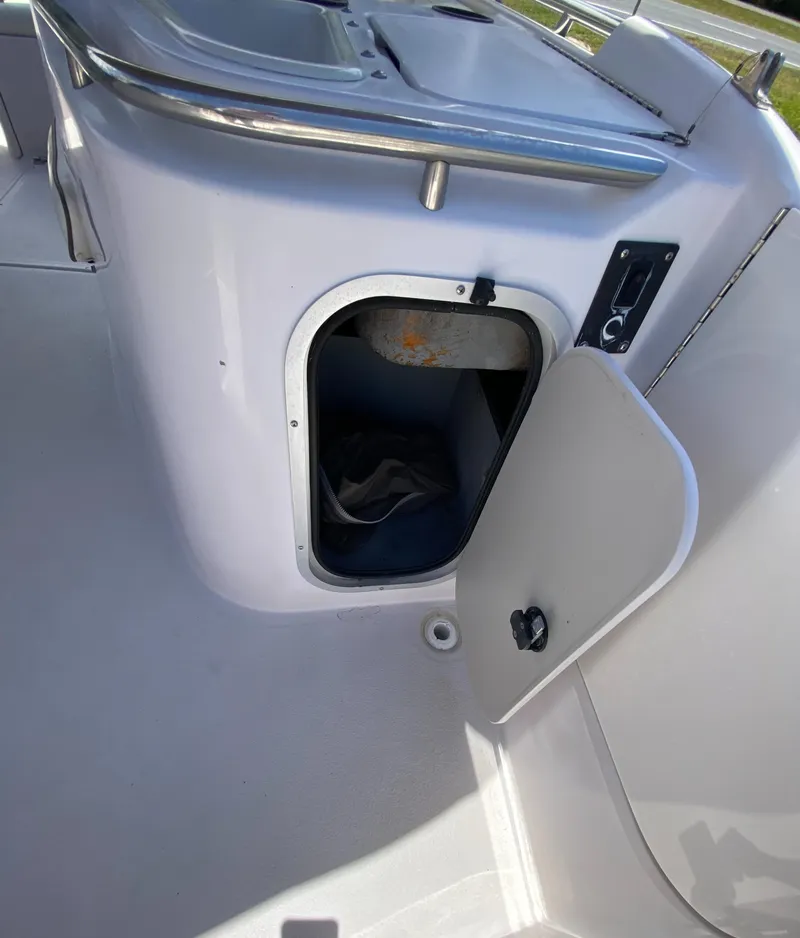 Slide: The Image of 1997 Chaparral 250 Sunseta boat storage compartment with open door. - 14