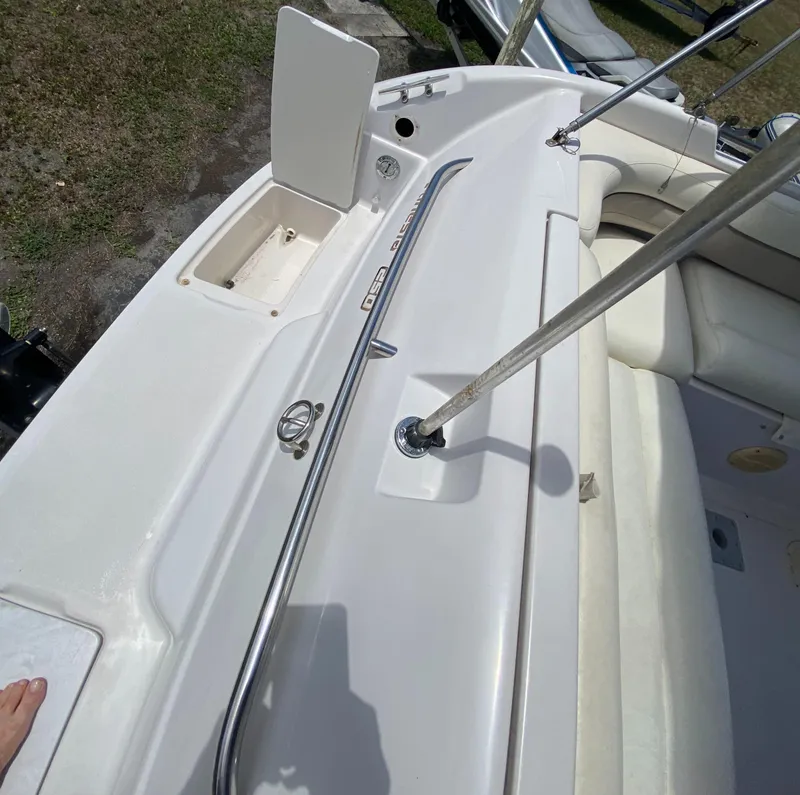 Slide: The Image of 1997 Chaparral 250 Sunseta boat interior, featuring white seating and storage compartments. - 19
