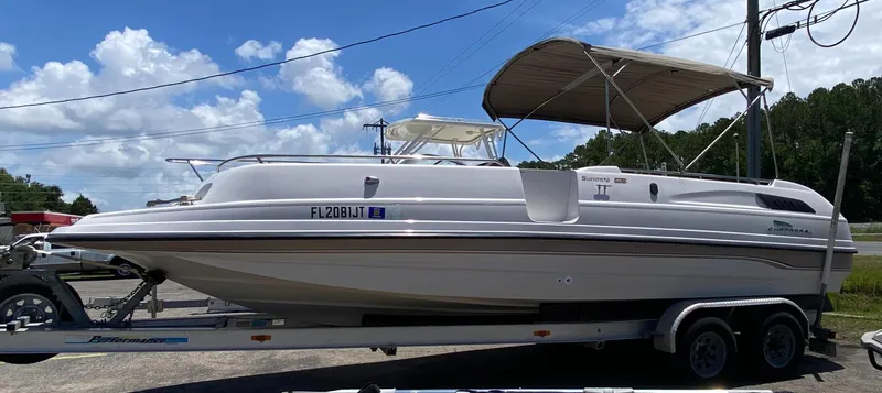 Slide: The Image of 1997 Chaparral 250 Sunseta boat on a trailer under a blue sky. - 2