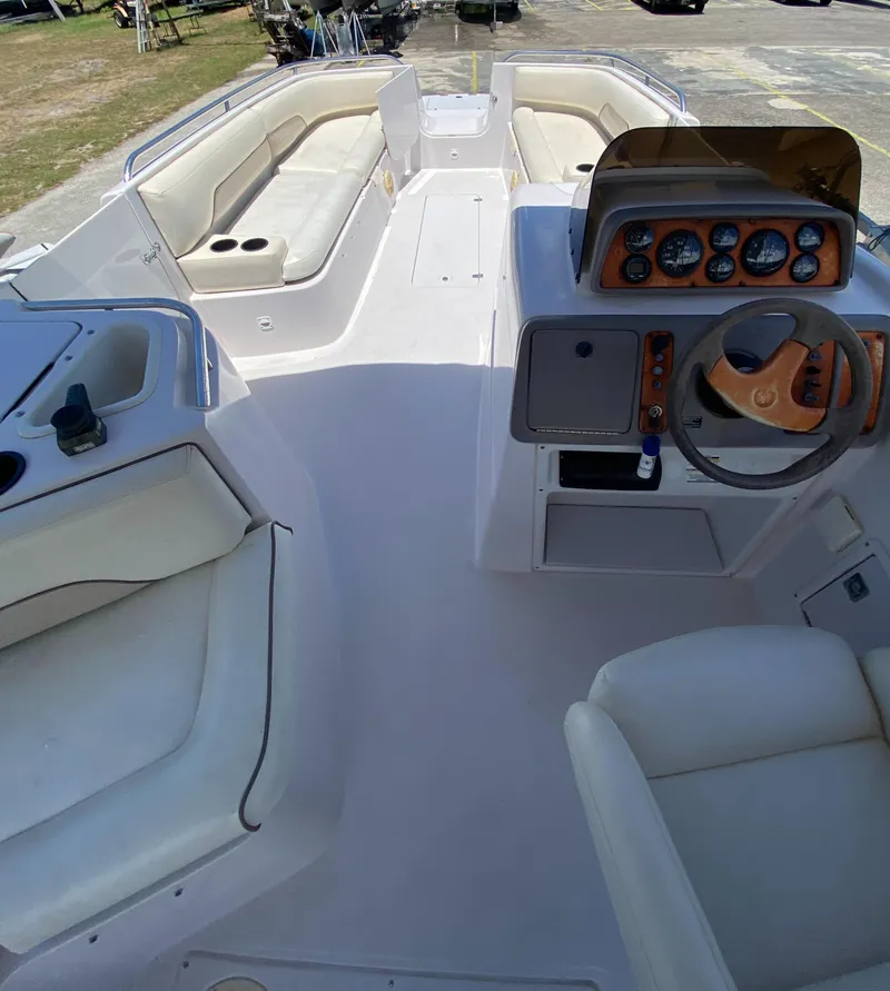 Slide: The Image of 1997 Chaparral 250 Sunseta boat interior with white seating and dashboard. - 7