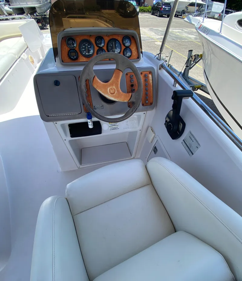Slide: The Image of 1997 Chaparral 250 Sunseta boat cockpit with steering wheel and control panel. - 8