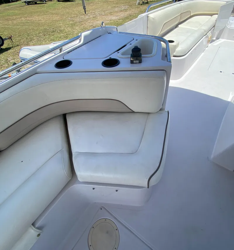 Slide: The Image of 1997 Chaparral 250 Sunseta boat interior with white seating and cup holders. - 9