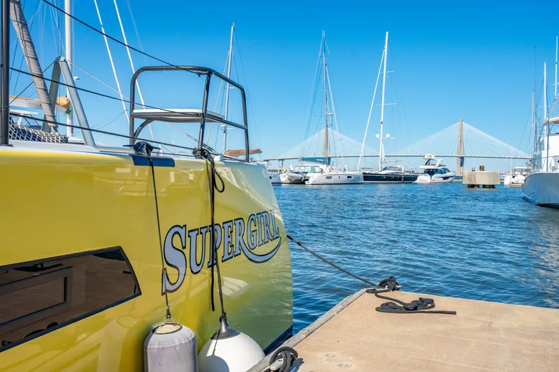 Slide: The Image of Yellow Balance 442 catamaran named "Supergirl" docked in a marina, 2022 model. - 11