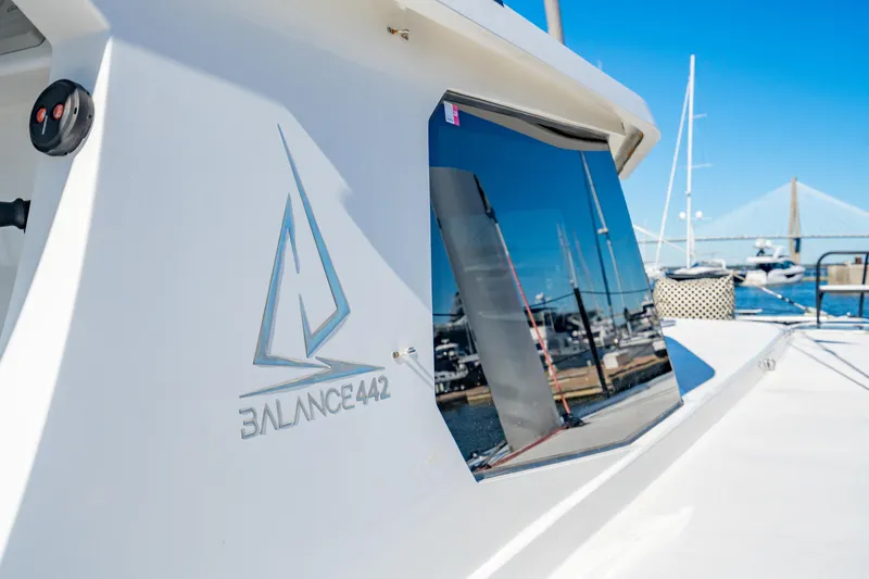 Slide: The Image of Balance 442 catamaran, 2022 model, docked with marina reflection on window. - 13