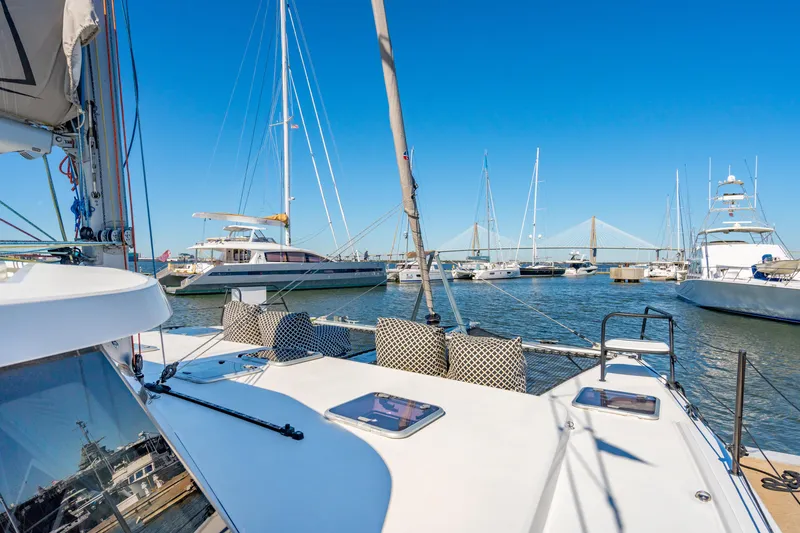 Slide: The Image of Sailboats docked in a marina, featuring a 2022 Balance 442 catamaran under clear blue skies. - 14