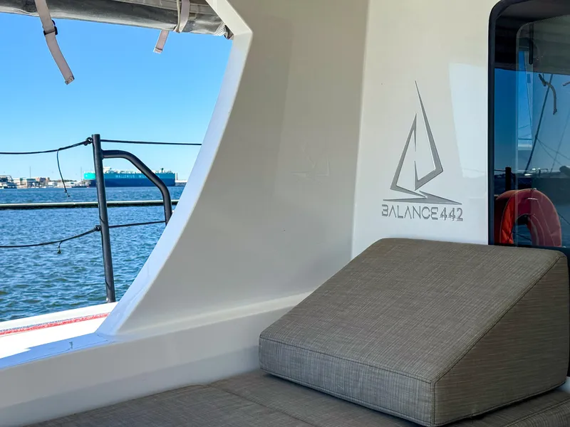 Slide: The Image of Balance 442 catamaran interior with cushioned seating, ocean view, and modern design, 2022 model. - 23
