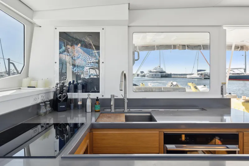 Slide: The Image of Modern yacht kitchen with sleek countertops, large windows, and marina view. Balance 442, 2022 model. - 39
