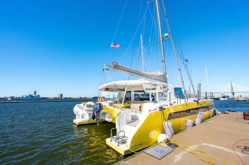 Slide: The Image of Yellow Balance 442 catamaran docked at marina, clear blue sky, 2022 model. - 7