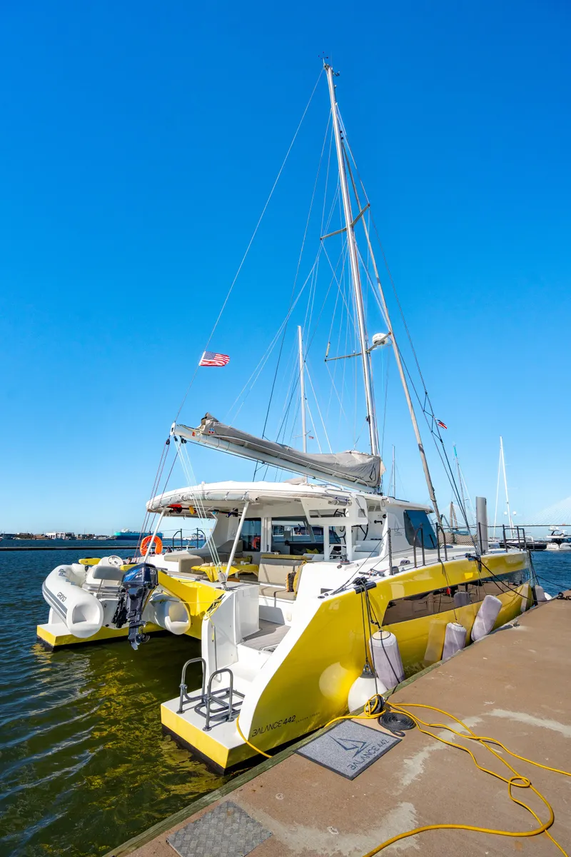 Slide: The Image of Yellow Balance 442 catamaran docked, 2022 model, under clear blue sky. - 8