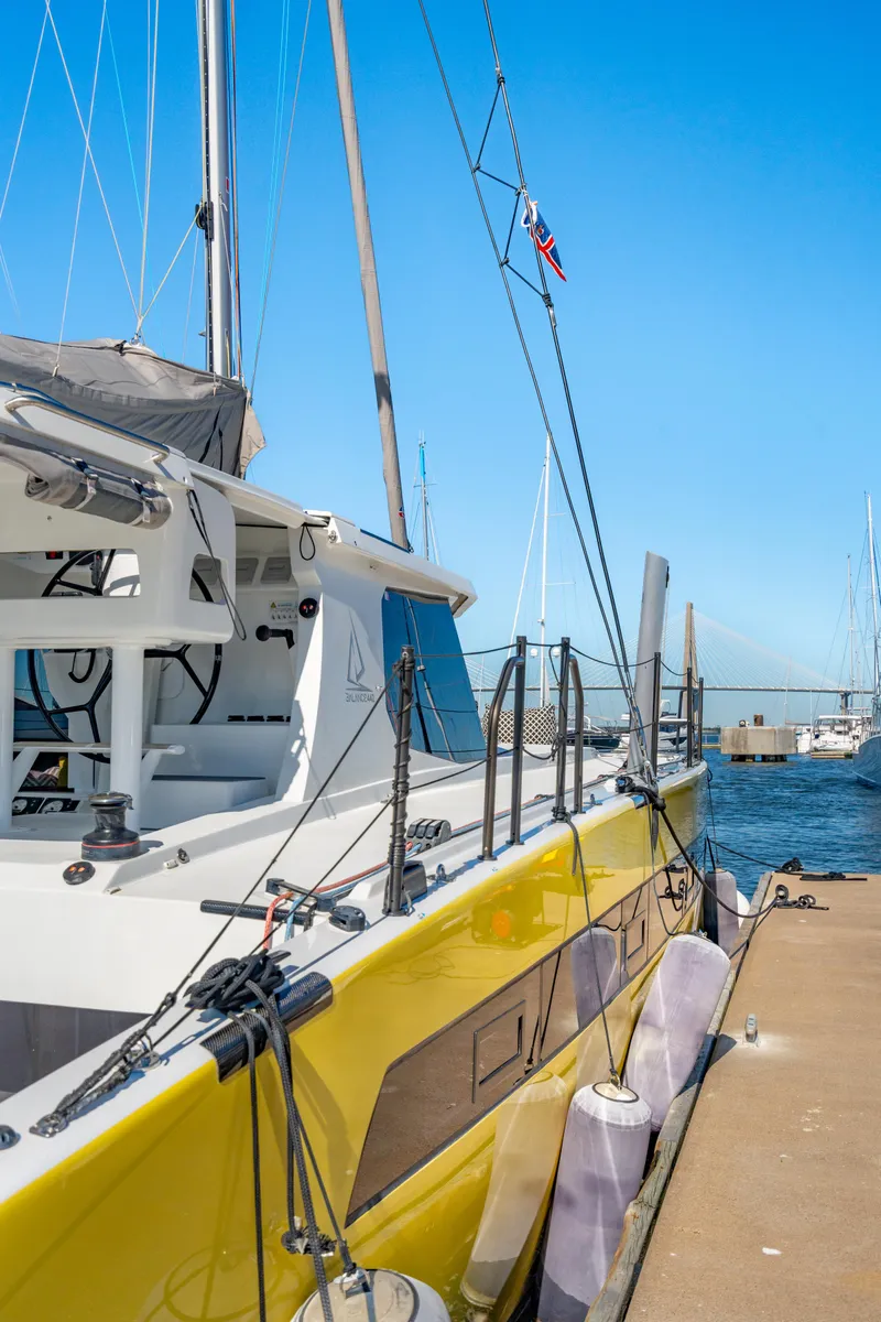 Slide: The Image of Yellow Balance 442 catamaran docked at marina, clear blue sky, 2022 model. - 9