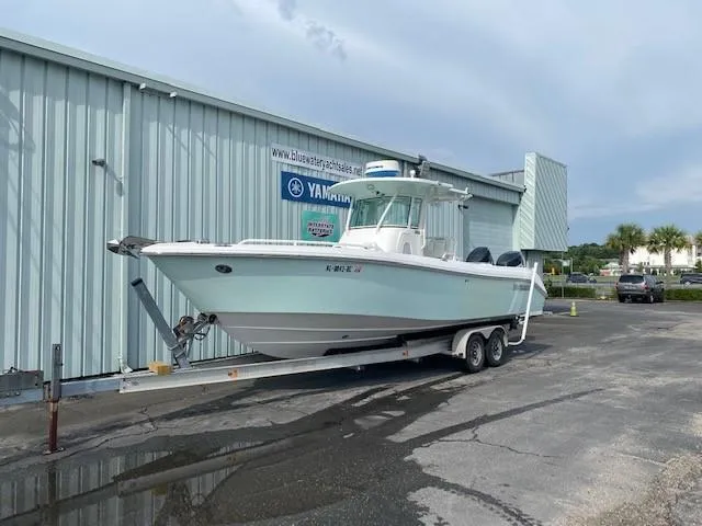 Slide: The Image of 2008 Everglades 290 CC boat on a trailer outside a metal building. - 1