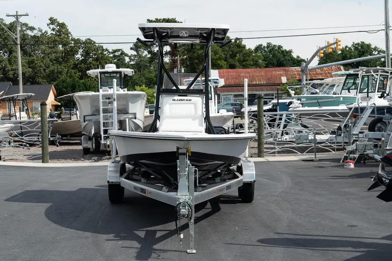 Slide: The Image of 2025 Blazer 2220 Fisherman boat on a trailer in a marina. - 2