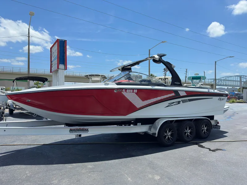 The Image of 2015 Tigé Z3 boat on a trailer, red and white exterior, parked outdoors. - 0