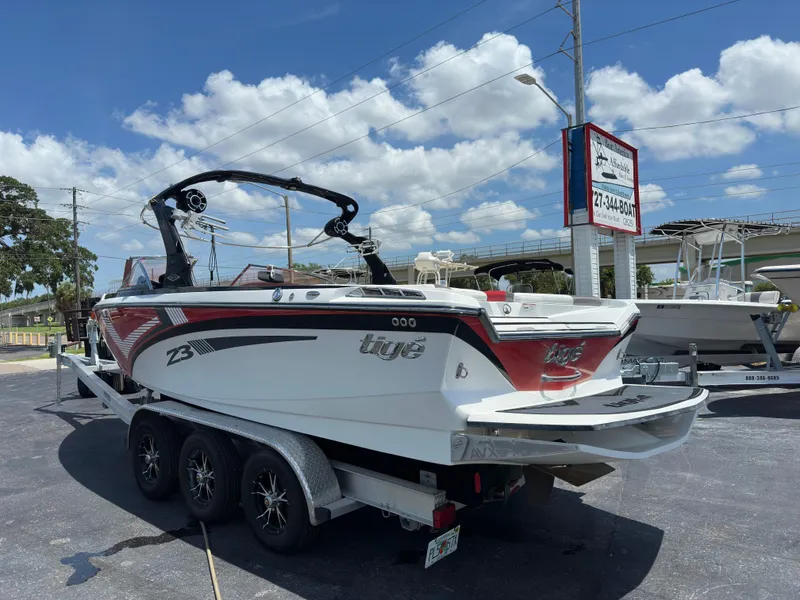 Slide: The Image of 2015 Tigé Z3 boat on a trailer in a parking lot under a clear sky. - 1