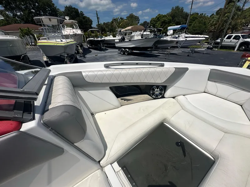 Slide: The Image of 2015 Tigé Z3 boat interior with white leather seating and speaker, docked among other boats. - 7