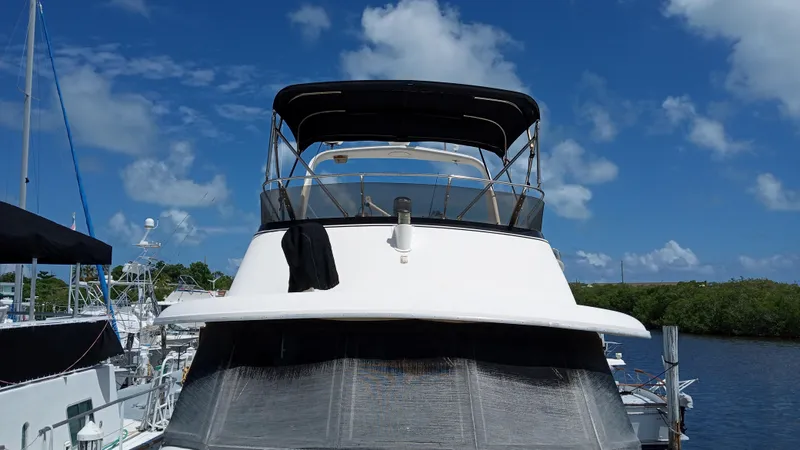 Slide: The Image of 1986 Hatteras 53 Extended Deckhouse Motor Yacht docked under a clear blue sky. - 16
