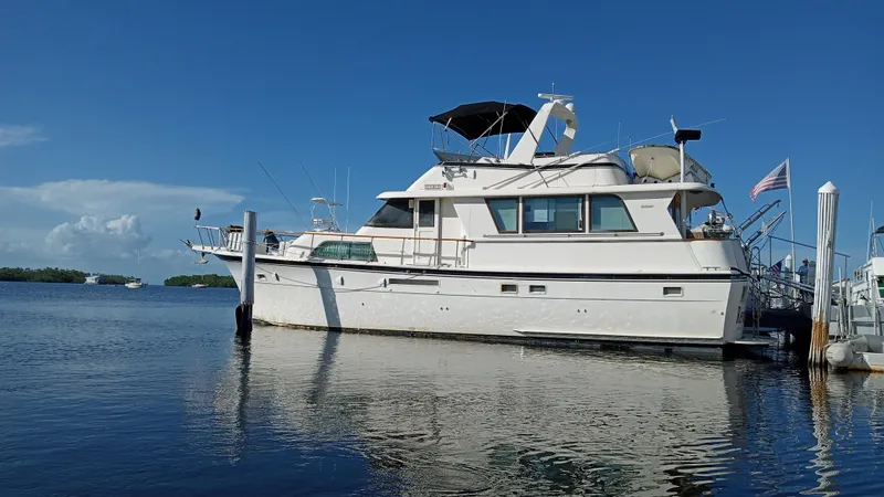 Slide: The Image of 1986 Hatteras 53 Extended Deckhouse Motor Yacht docked on calm water. - 17
