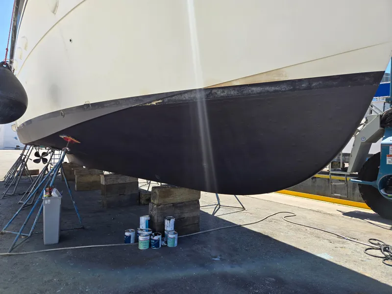 Slide: The Image of 1986 Hatteras 53 Extended Deckhouse yacht undergoing maintenance with paint cans nearby. - 25