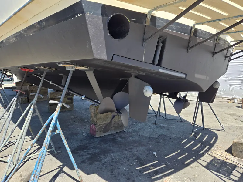 Slide: The Image of 1986 Hatteras 53 Extended Deckhouse yacht on stands, showcasing propellers and hull details. - 30