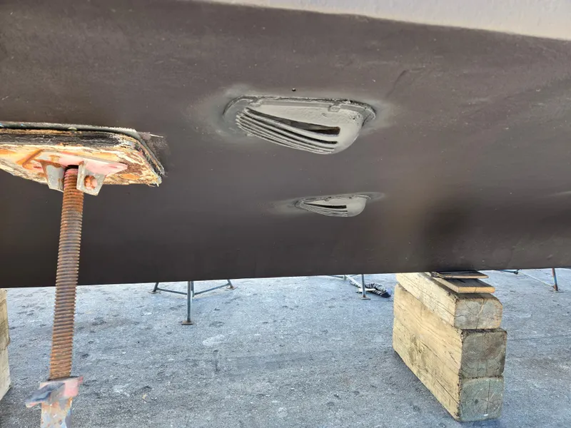 Slide: The Image of Bottom view of a 1986 Hatteras 53 Extended Deckhouse on blocks, showing hull details. - 32